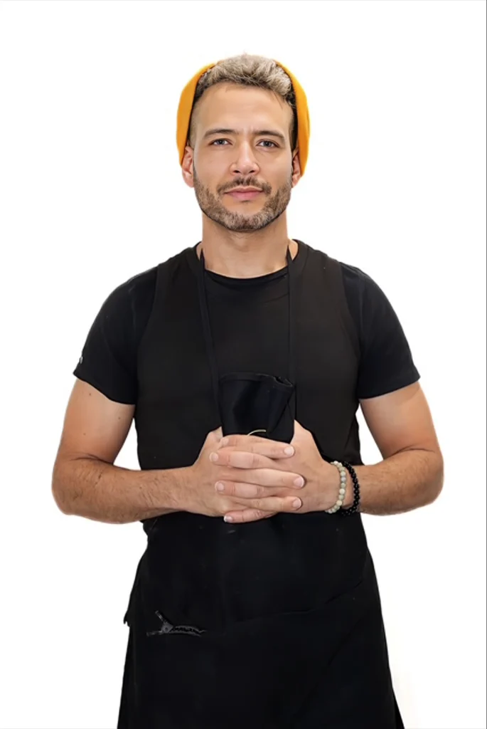 Man wearing black apron with yellow beanie